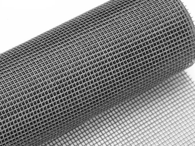 Um rolo de tela de proteção solar de fibra de vidro revestida de PVC cinza com orifício de malha resistente.