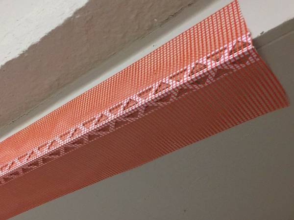 Red PVC corner beads with fiberglass mesh can be used in door frame construction.