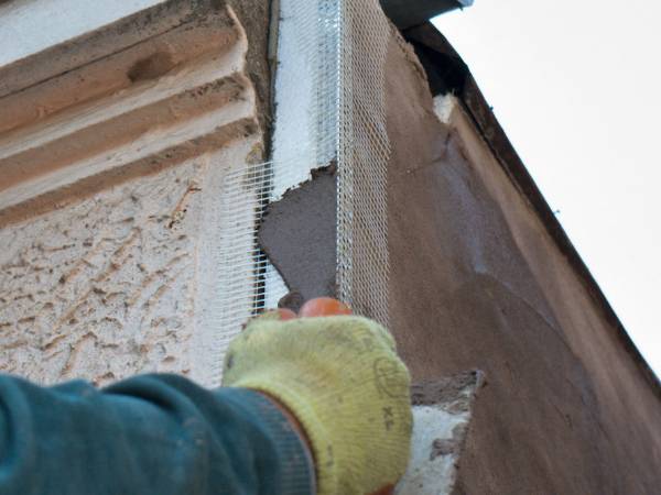 Use contas de canto de PVC com malha de fibra de vidro para engessar o canto da parede de concreto.