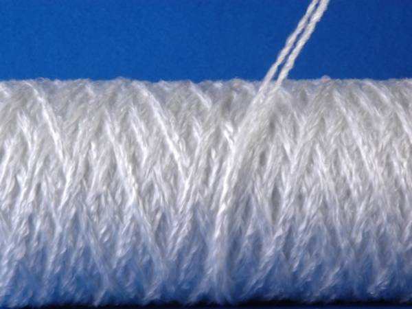 Un rouleau de fil de fibre de verre texturé de couleur blanche.